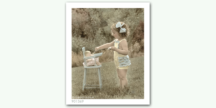 photograph of girl feeding doll