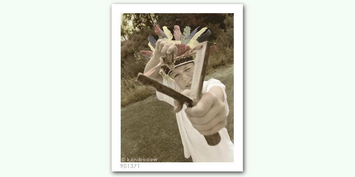 photograph of boy with slingshot