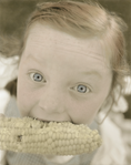 photograph of girl eating corn