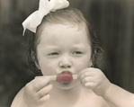 photograph of girl eating popsicle